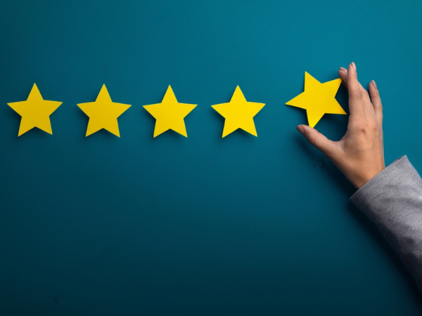 Satisfaction concept. Woman hand giving five star rating on green background