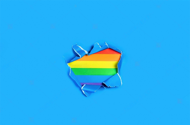 A flag with the colors of the rainbow. Underneath, torn blue paper