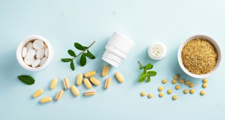 Vitamins and herbal supplements in jars with a green plant on a blue background. Biologically active additives. Dietary supplements.