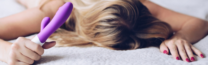 Woman holding a squirting dildo on squirting blanket