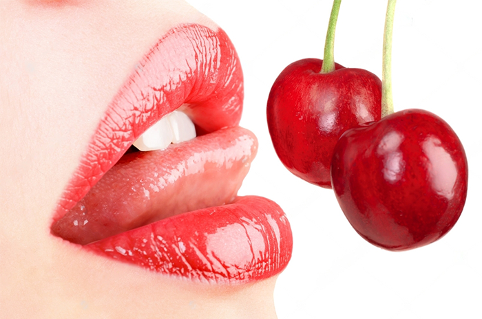 Juuice girl's lips about to lick a couple of cherries